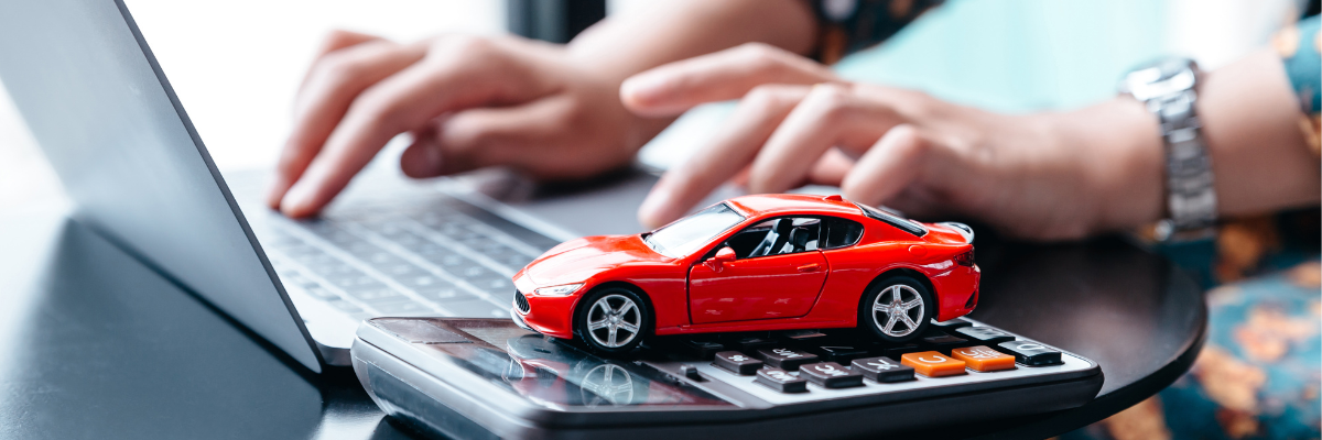 Mani al computer con calcolatrice e modellino di auto rossa per il calcolo della tassazione fringe benefit e welfare aziendale