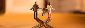 Statuette di una famiglia in equilibrio su forchette, simbolo di conciliazione tra vita familiare e lavoro